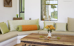 orange petaled flower on white Buddha ceramic vase on coffee table